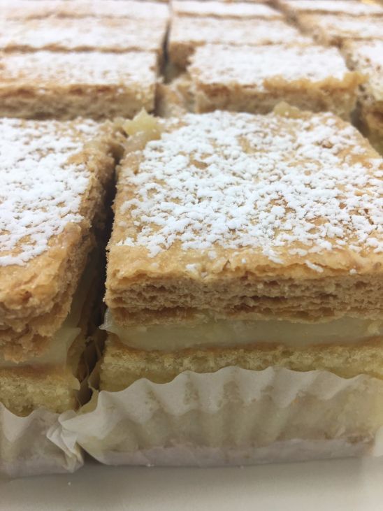 A close up of a piece of cake with powdered sugar on top.
