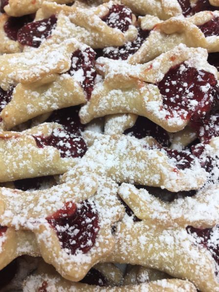 A close up of a pile of cookies with powdered sugar on top