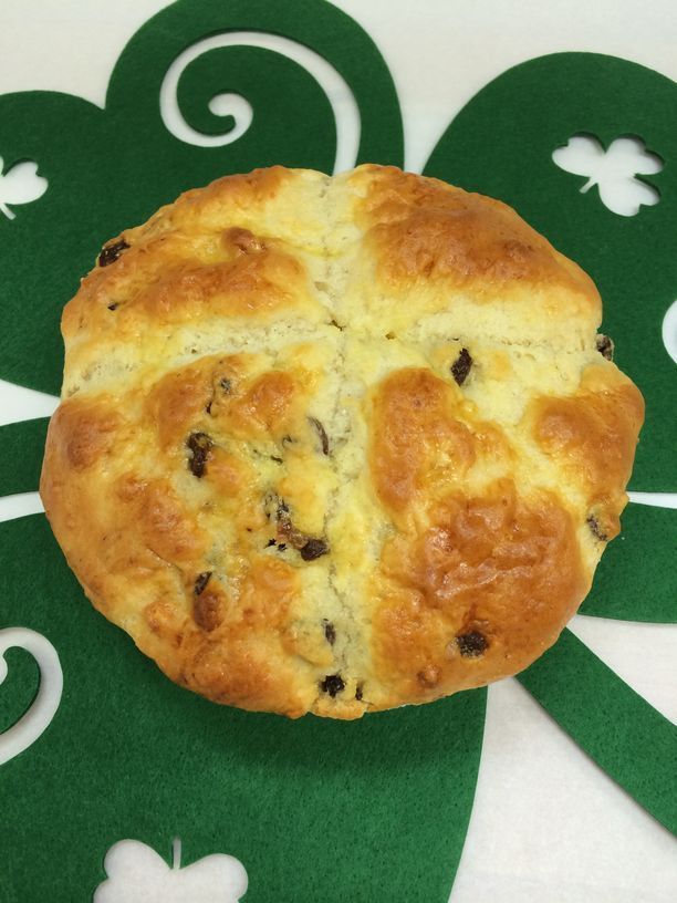 A pastry with raisins sits on a green place mat