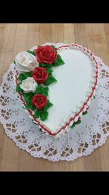 A heart shaped cake with red and white roses on it