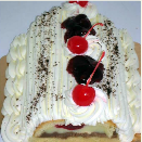 A cake with whipped cream and cherries on top has been cut in half.