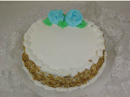 A cake with white frosting and blue roses on top