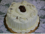 A cake with white frosting and a cherry on top