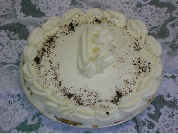 A cake with whipped cream and chocolate sprinkles on it