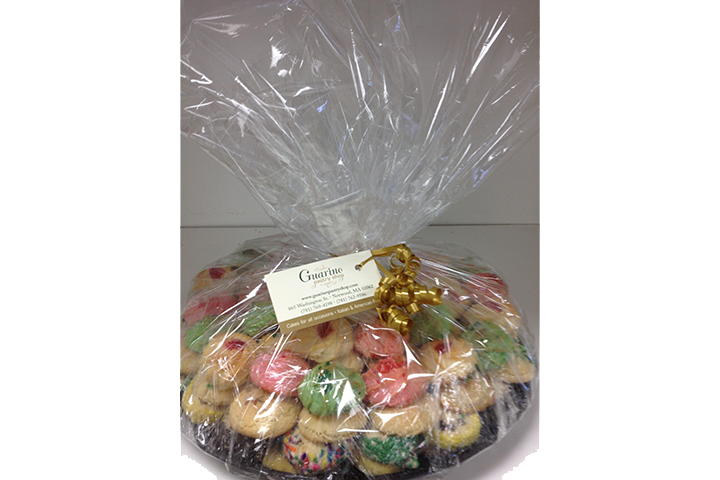 A plastic bag filled with a variety of cookies is sitting on a table.