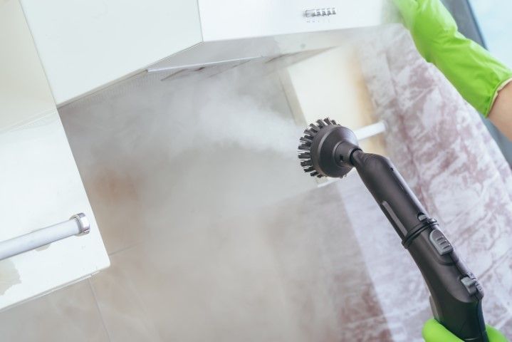 The kitchen hood is being cleaned by a machine.