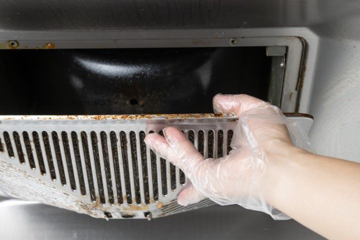 A kitchen hood is being removed from its position to be cleaned.