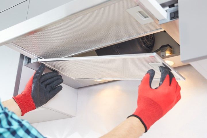 A man is putting back the filter after having it cleaned.