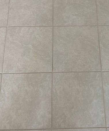 Light beige tile floor, grout lines visible, square tiles.