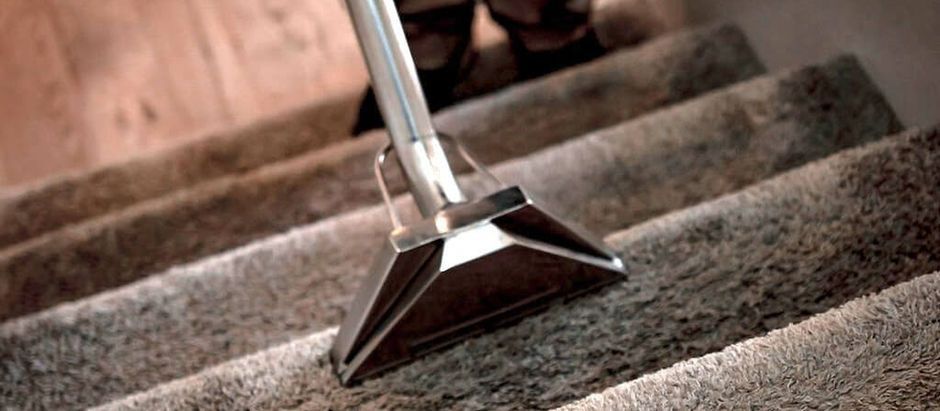Vacuum cleaner head cleaning a carpeted staircase.