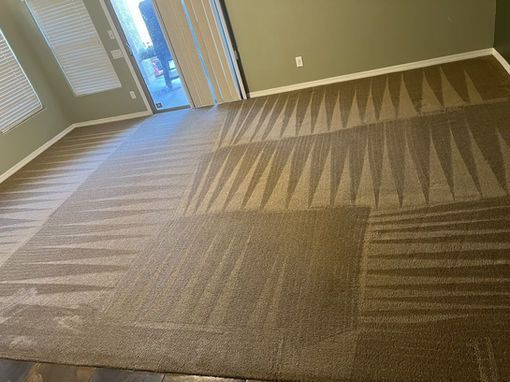 Cleaned carpet in a room with geometric patterns, light brown color, and a sliding glass door.