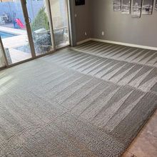 Gray carpet with a patterned design, near sliding doors to a pool area and framed artwork on a wall.
