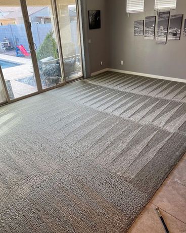 Gray carpet with geometric pattern in a living room, next to sliding glass doors and pool.