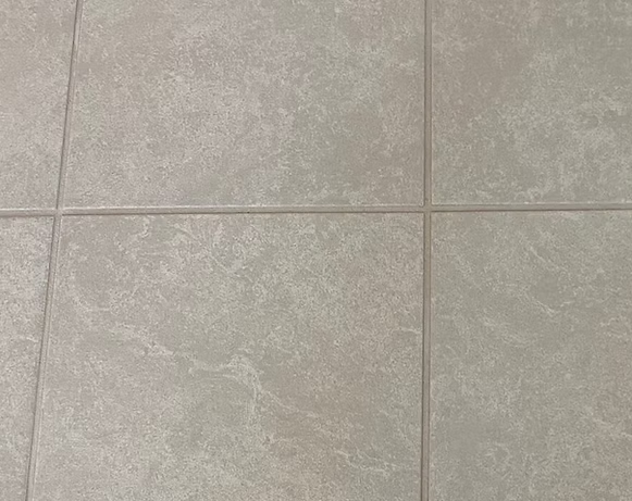 Gray ceramic tile floor with grout lines.