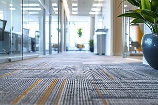 Close-up of gray and yellow patterned office carpet in a bright hallway.