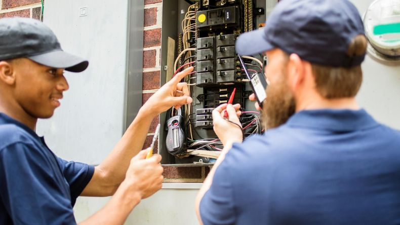 Electricians working on an electrical panel