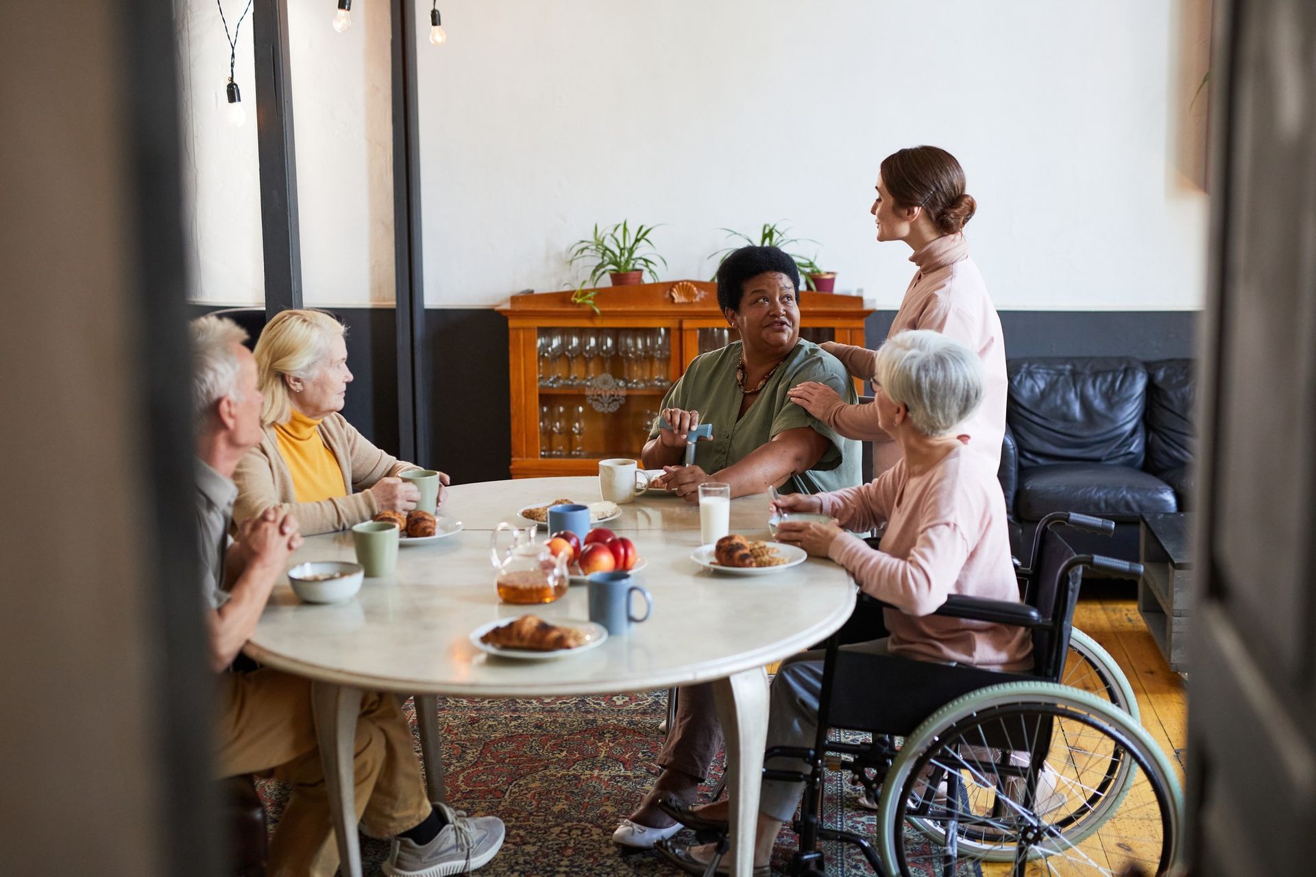 A group of elderly people are sitting around a table eating food.