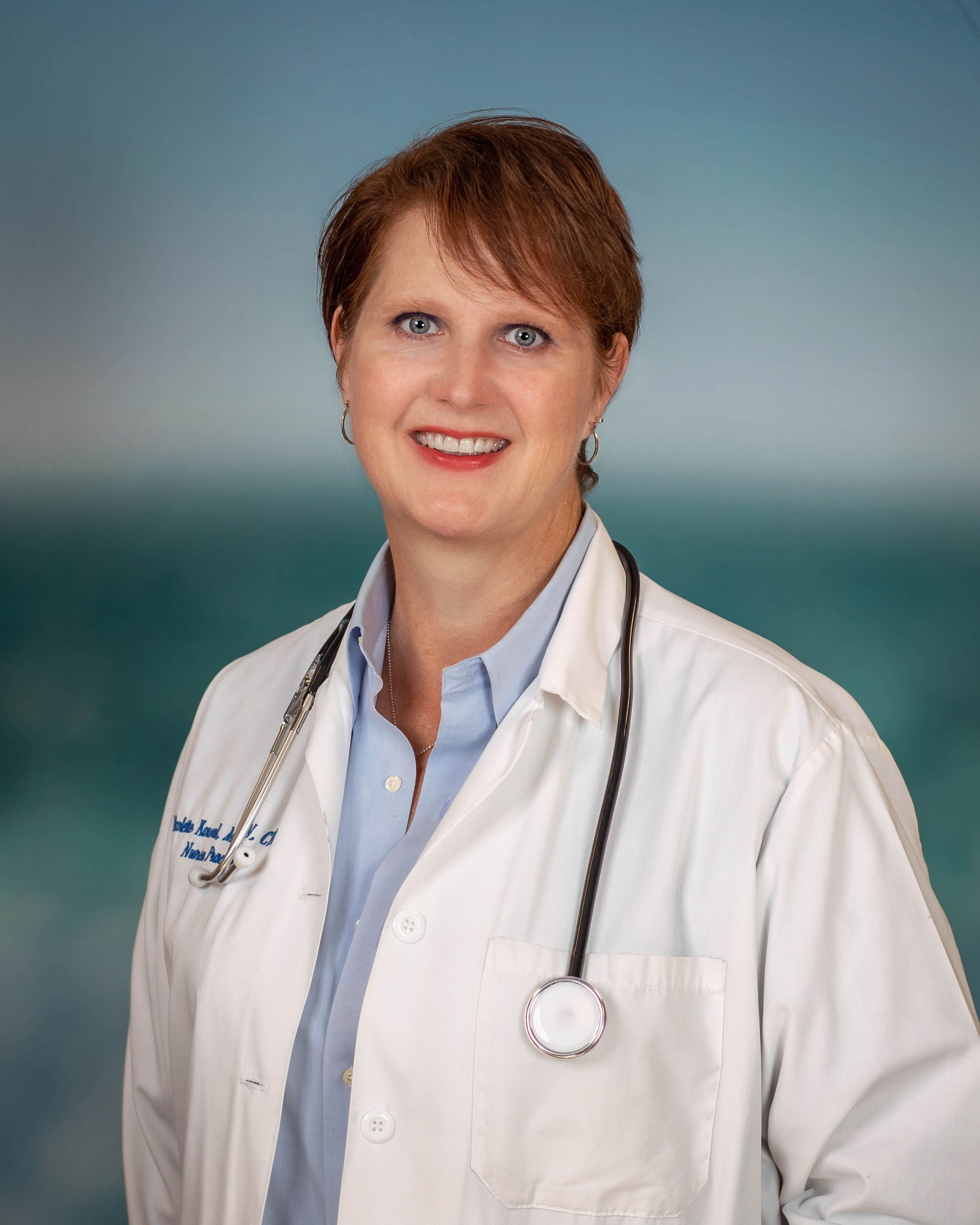 A woman in a white lab coat with a stethoscope around her neck.