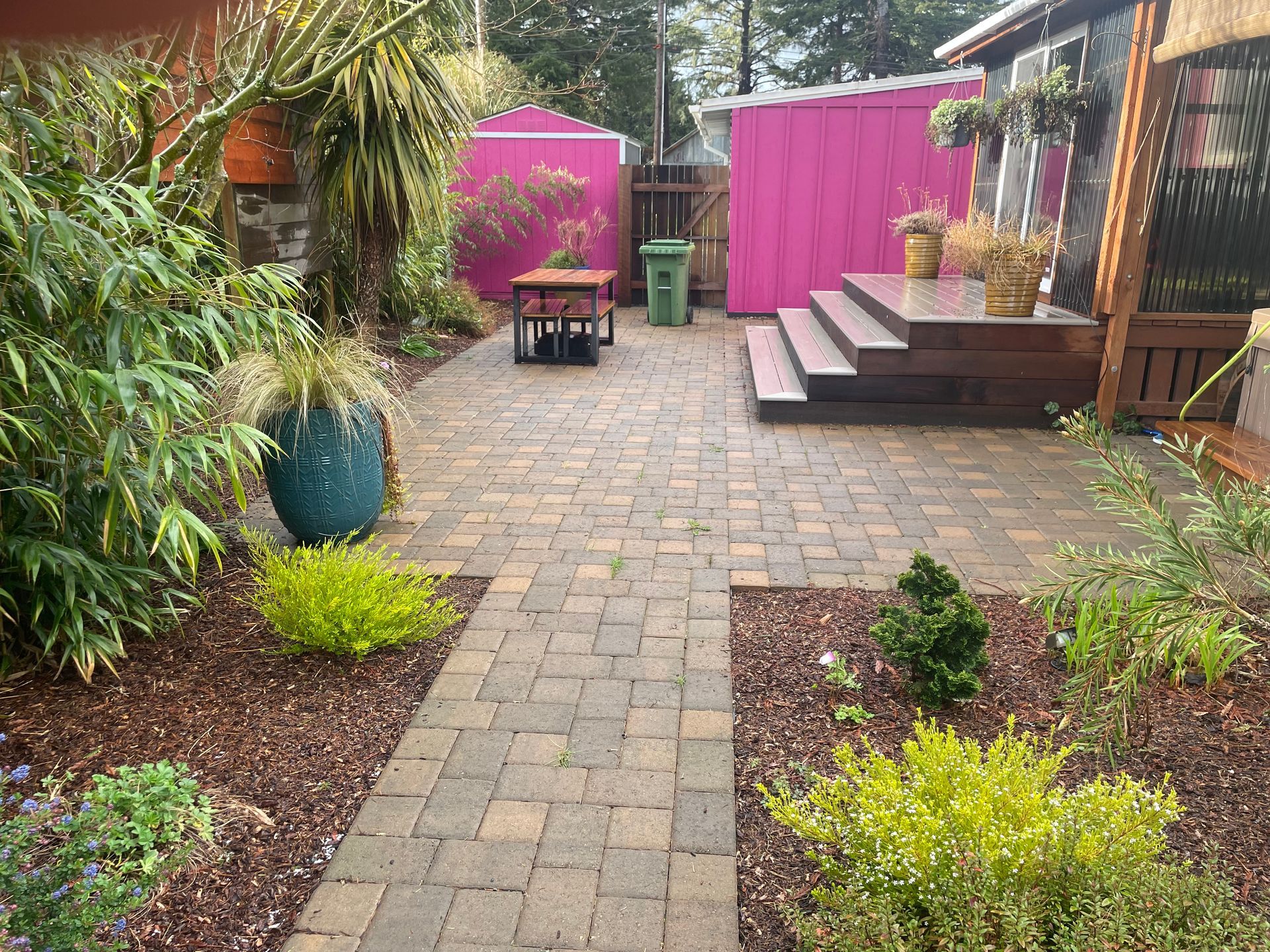 Outdoor patio with seating, pergola, fire pit, and tiered stone steps.
