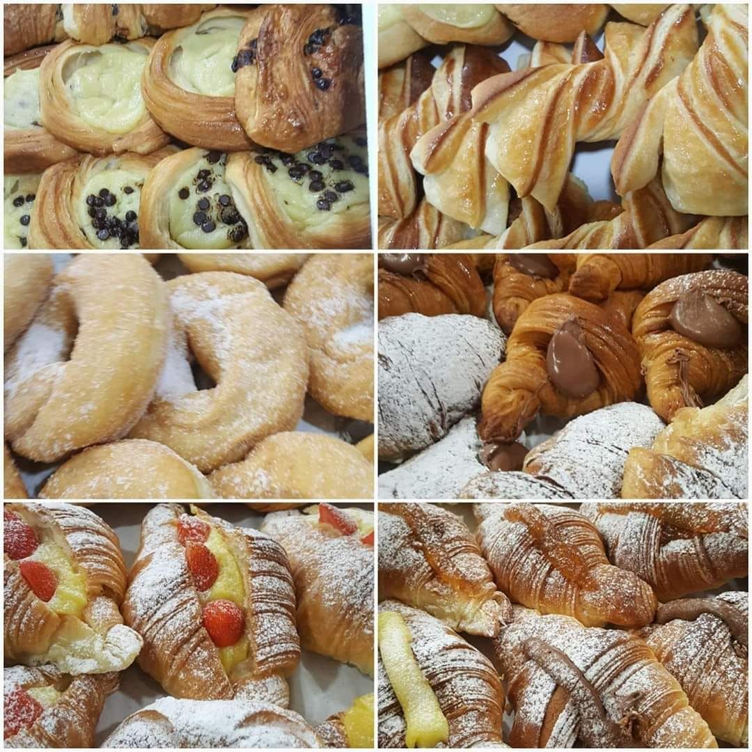 Assortimento di dolci da forno: ripieni di crema, con gocce di cioccolato, ciambelle, croissant spolverati di zucchero.