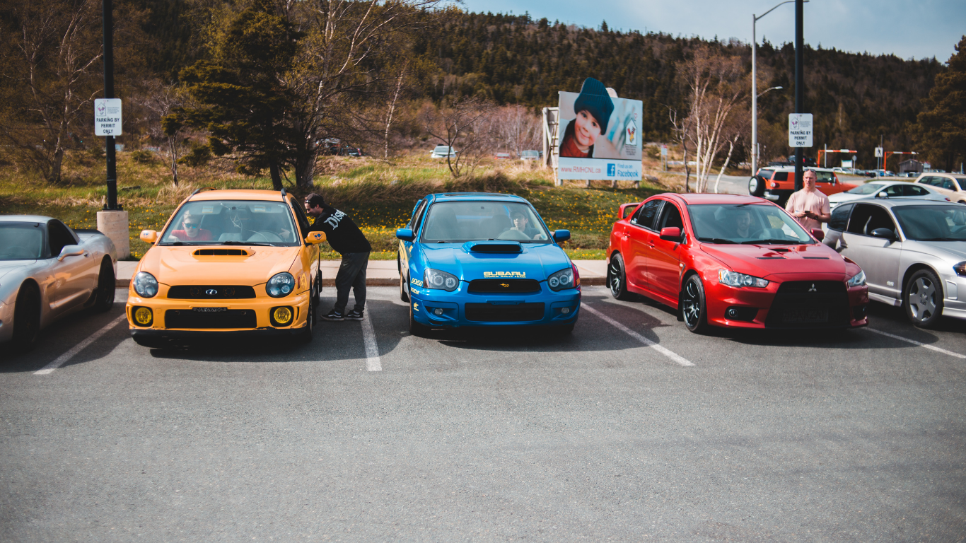 A row of cars are parked next to each other in a parking lot.