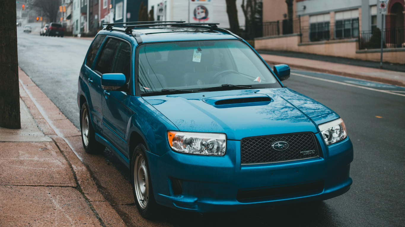 A blue bmw is parked in a parking lot.