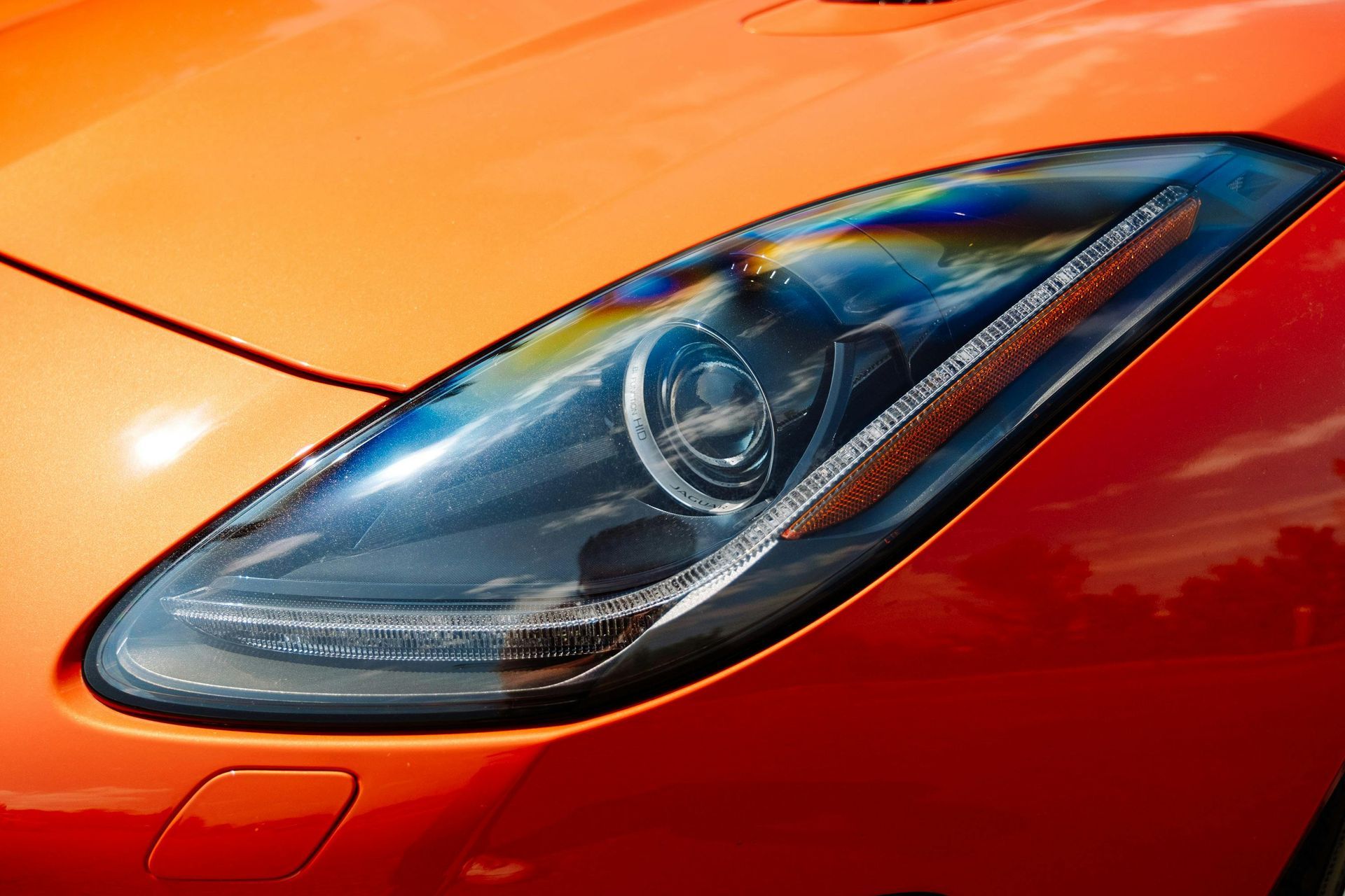 A close up of a red car 's headlight.
