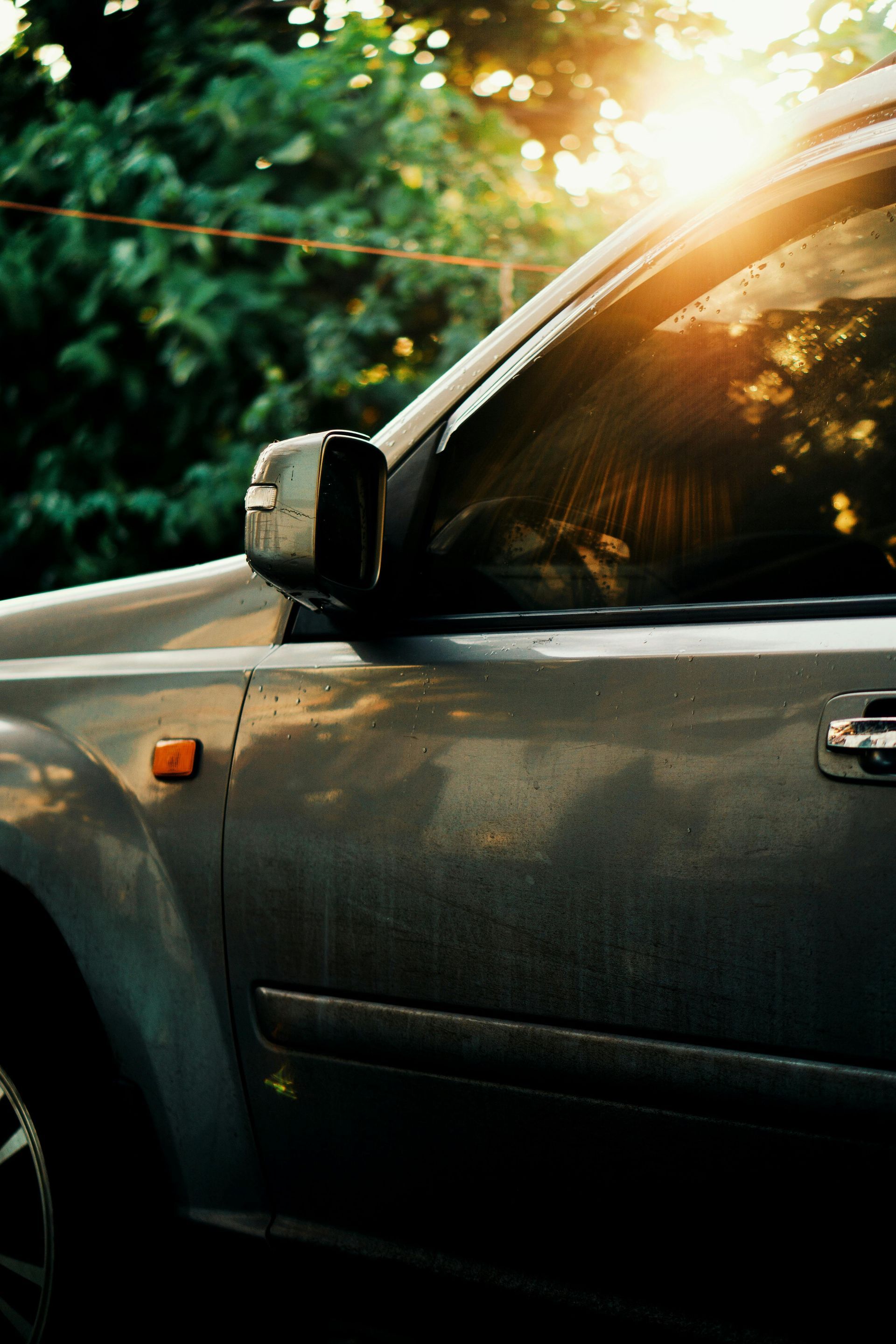 The sun is shining through the window of a car.