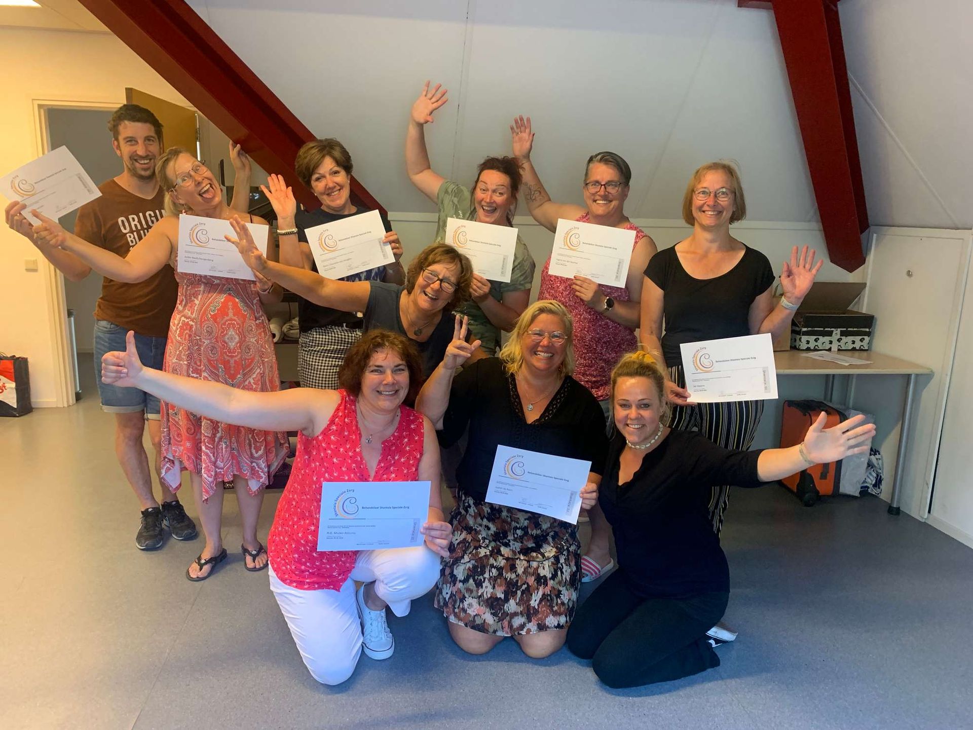 Een groep mensen poseert voor een foto terwijl ze papieren in hun handen houden.