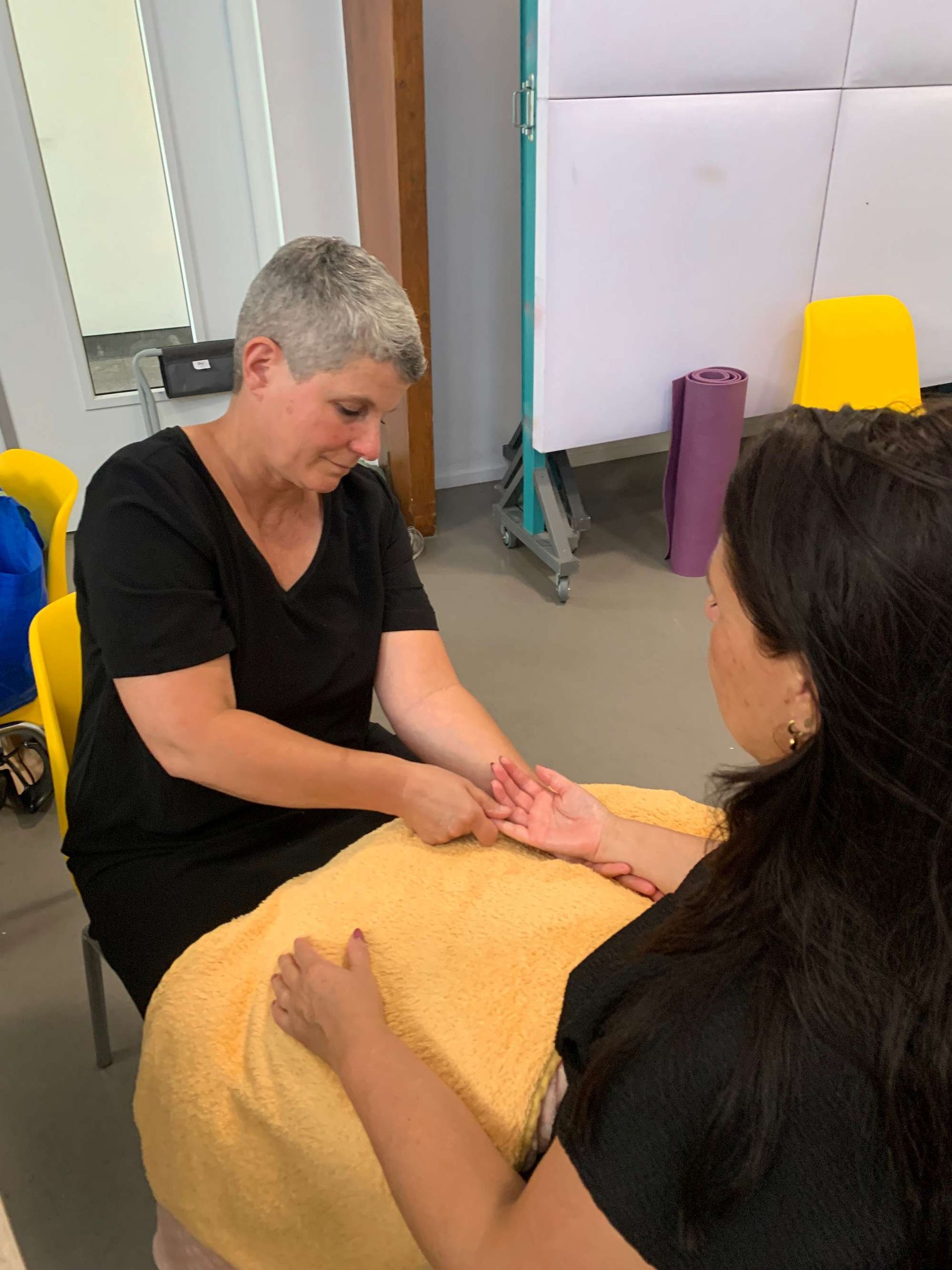 Een vrouw geeft een handmassage aan een andere vrouw