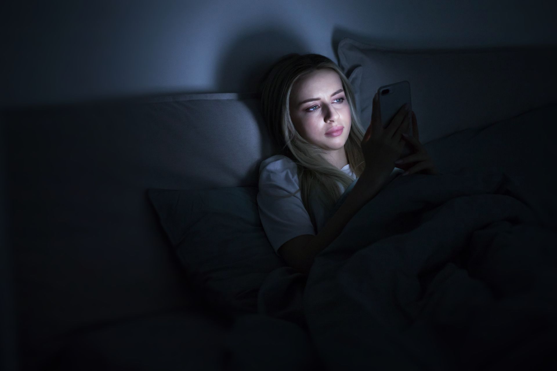 Woman alone in the dark looking at social media