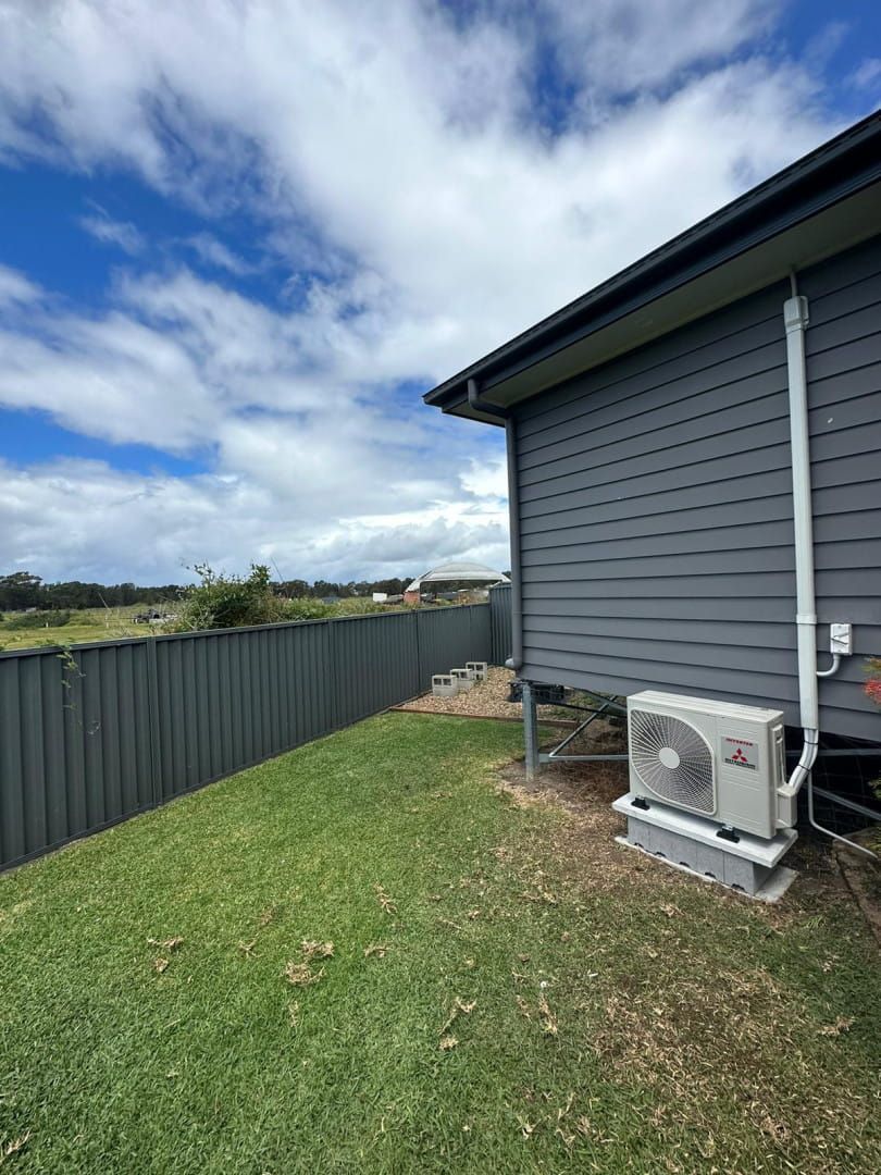 A House With Two Air Conditioners on the Side of It — Cool Heat Air Conditioning in Albion Park, NSW