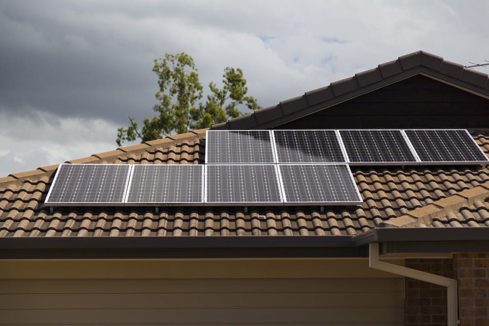 A Row of Solar Panels on the Roof of a House — Cool Heat Air Conditioning in Gerringong, NSW
