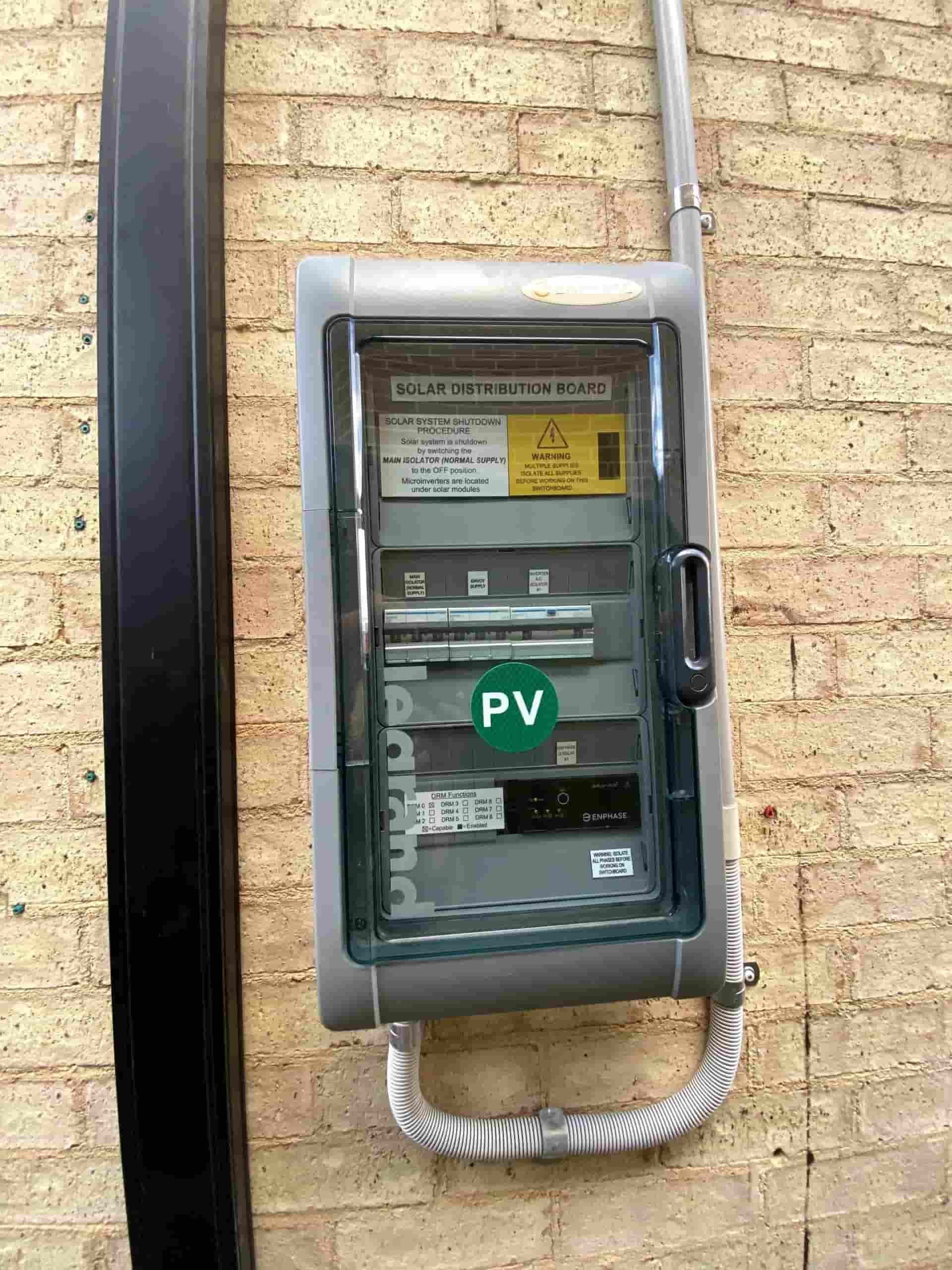 A PV Box is Hanging on a Brick Wall — Cool Heat Air Conditioning in Shellharbour, NSW