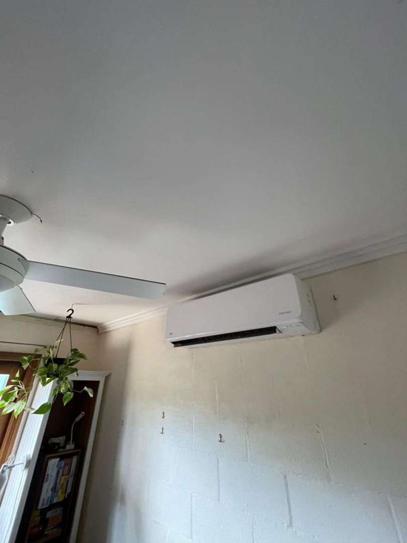 A Room With a Ceiling Fan and a Wall Mounted Air Conditioner — Cool Heat Air Conditioning in Albion Park, NSW