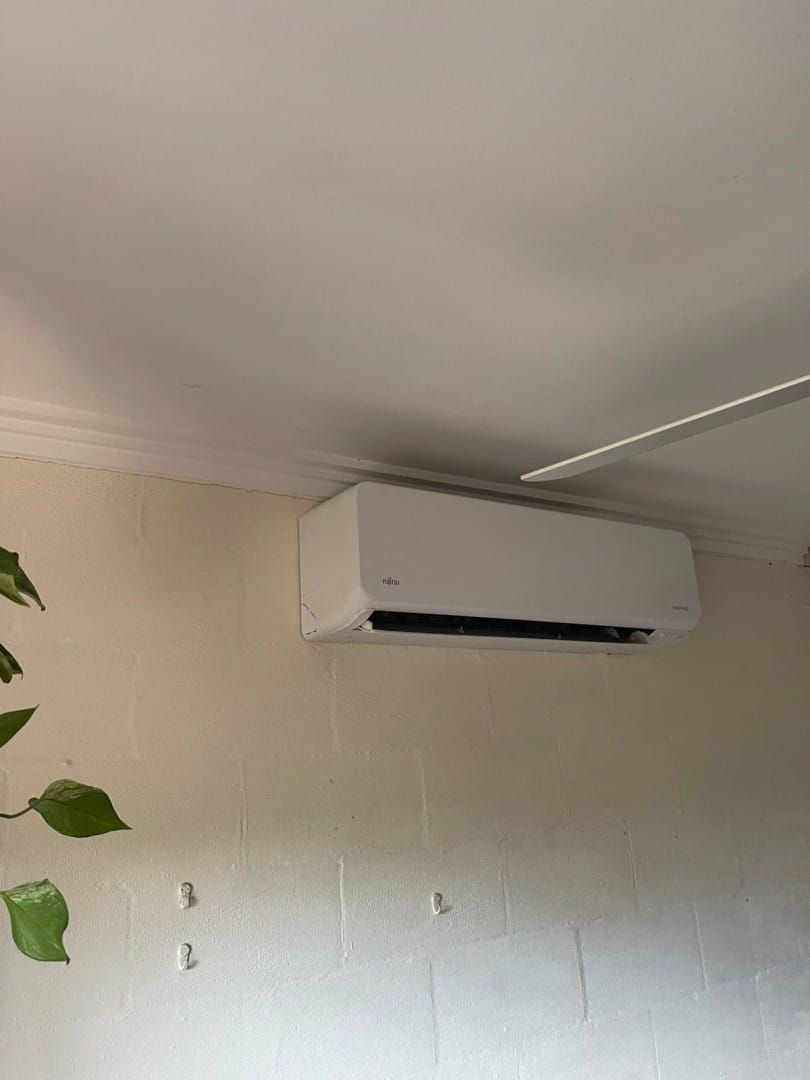 A White Air Conditioner is Hanging From the Ceiling in a Room — Cool Heat Air Conditioning in Albion Park, NSW