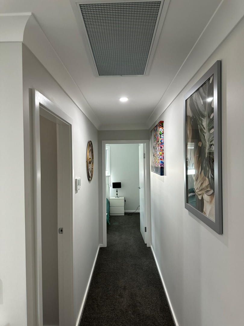A Long Hallway With a Picture of a Cat on the Wall — Cool Heat Air Conditioning in Albion Park, NSW