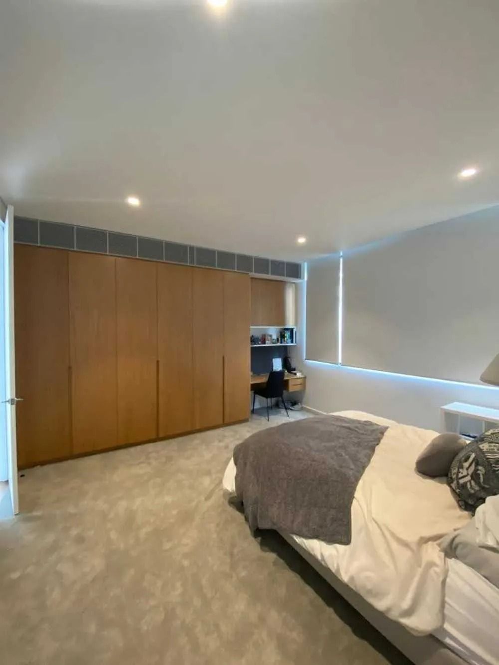 A Bedroom With a Large Bed and a Desk — Cool Heat Air Conditioning in Albion Park, NSW