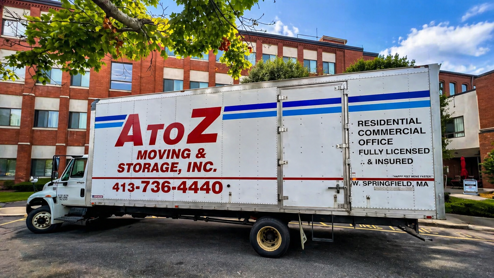 AtoZ moving truck parked on a street in front of brick apartment buildings.