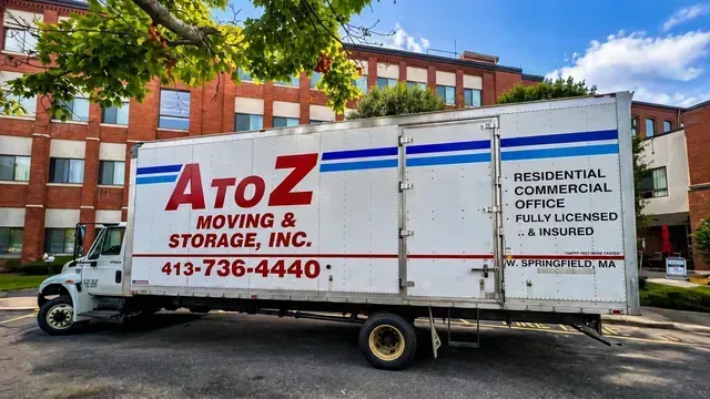 AtoZ Moving & Storage truck parked in front of a red brick building.