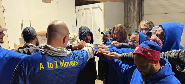 A to Z Movers team huddle in warehouse.