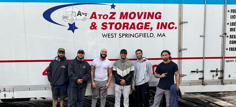 Five people posing in front of an A to Z Moving & Storage truck in West Springfield, MA