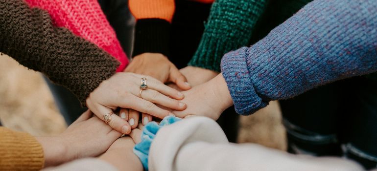 Hands stacked together in a circle, showing teamwork and unity.