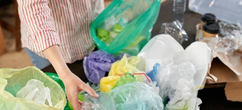 a woman sorting recycling and packing waste after move day