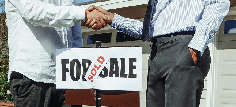 Buyers shaking hands after home sale closing