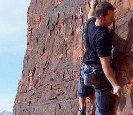 A man is climbing up a rock wall.