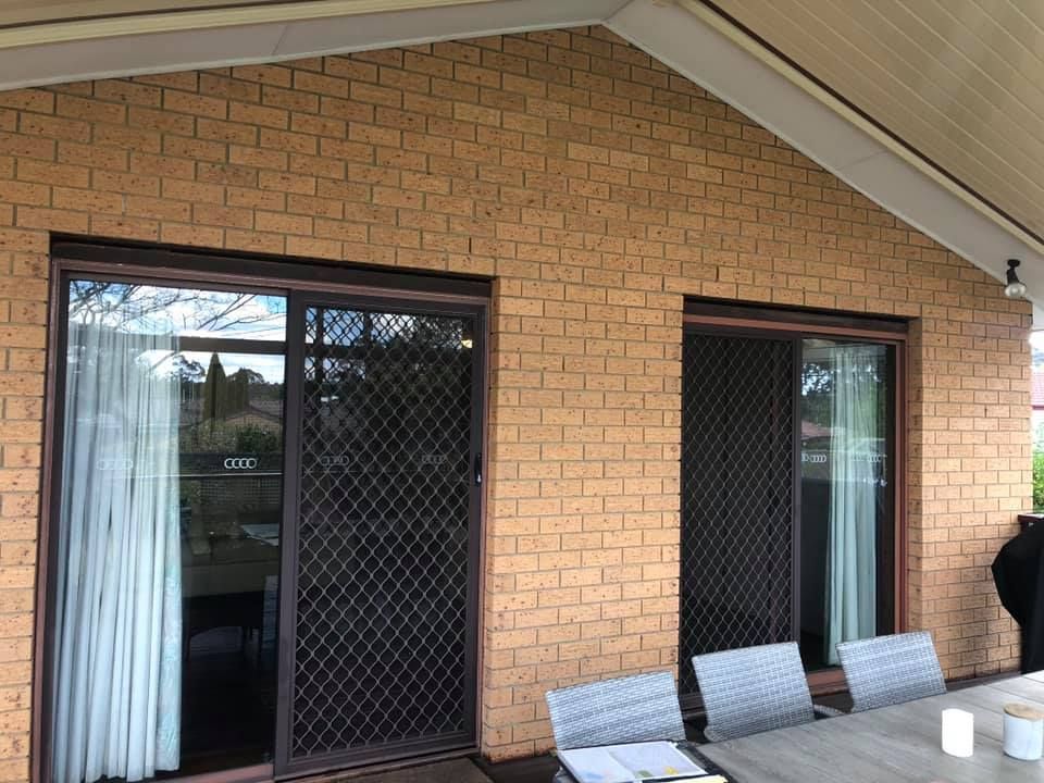 A Brick Building with A Table and Chairs in Front of It — P & M Maintenance Building Services in Yass River, NSW
