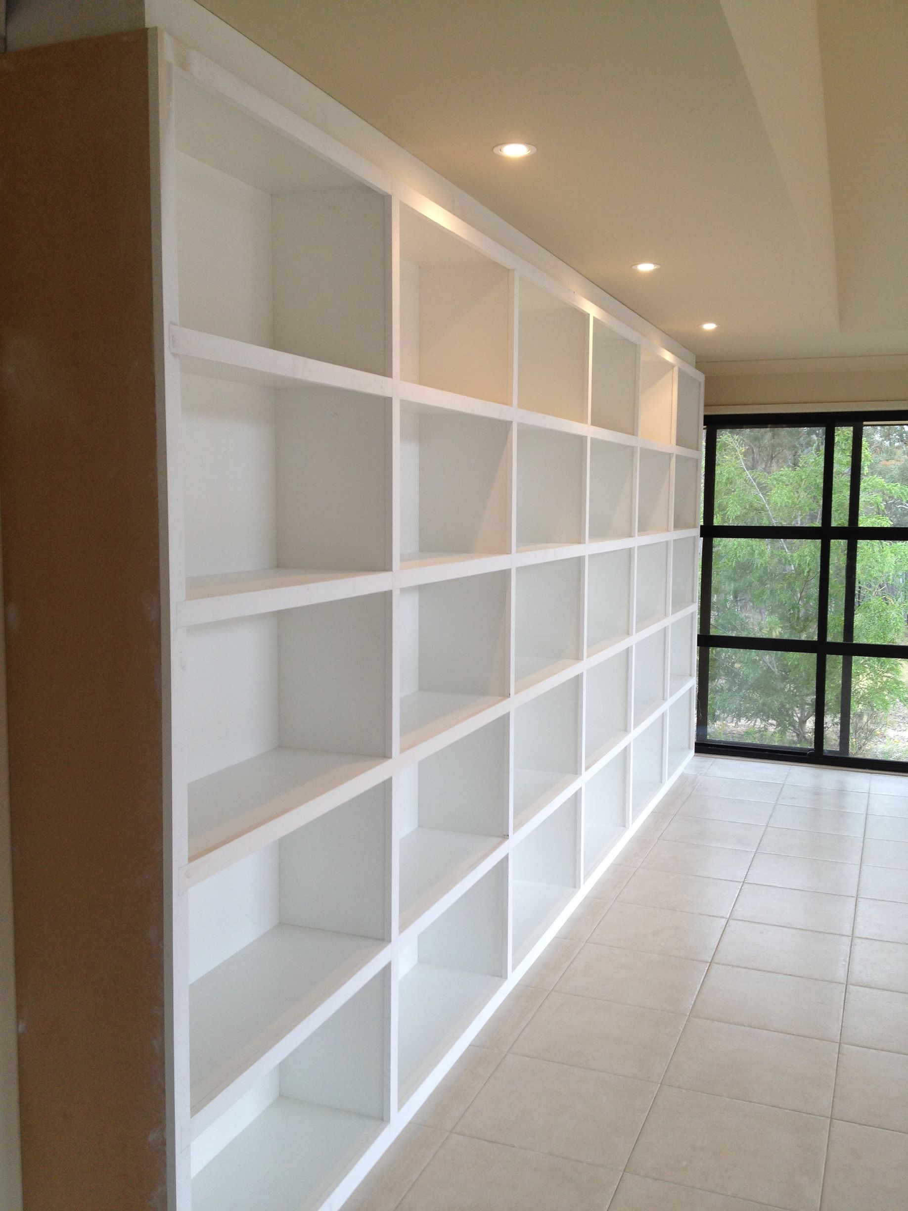 A Long Row of White Shelves in A Room with A Window — P & M Maintenance Building Services in Yass River, NSW