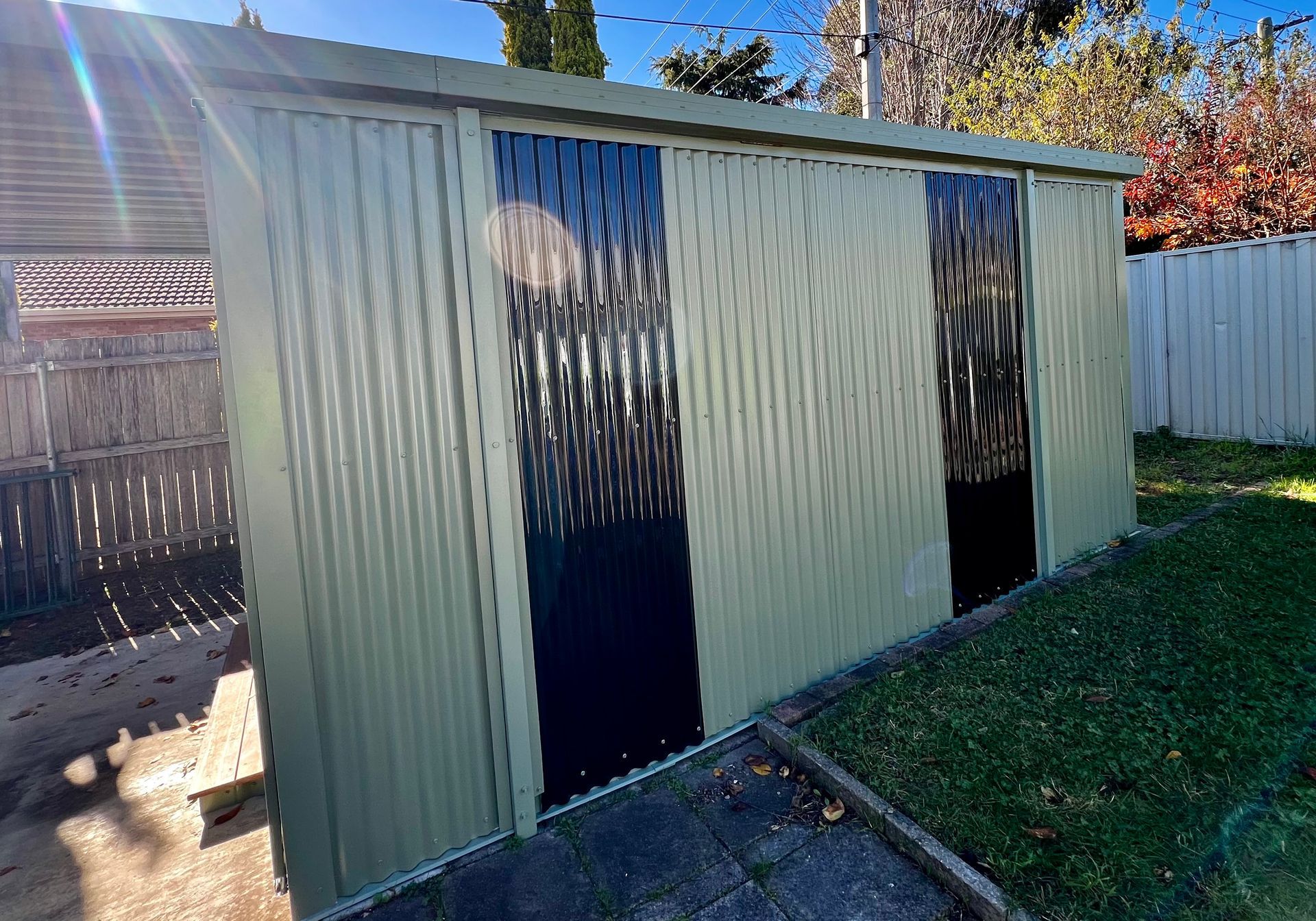 A Shed with Two Doors Painted Black and White in A Backyard — P & M Maintenance Building Services in Yass River, NSW