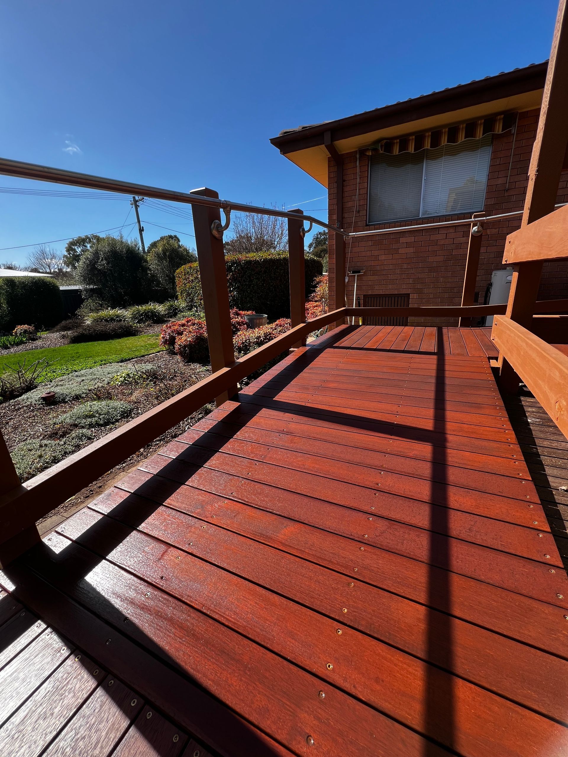 A Wooden Deck With Handrails — P & M Maintenance Building Services in Yass River, NSW